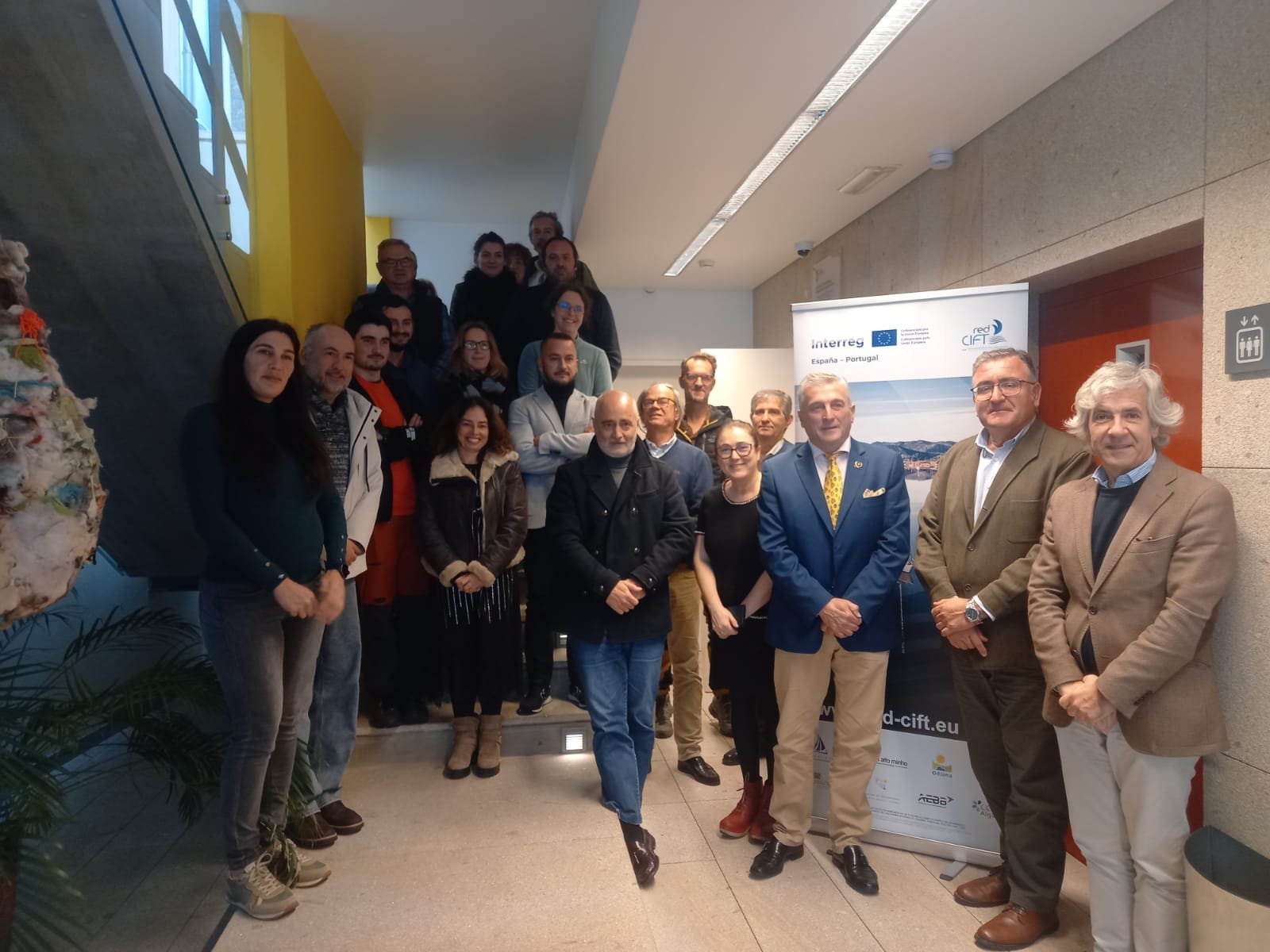 A imagem mostra os representantes das entidades que estão ligadas ao projeto de pé junto a umas escadas