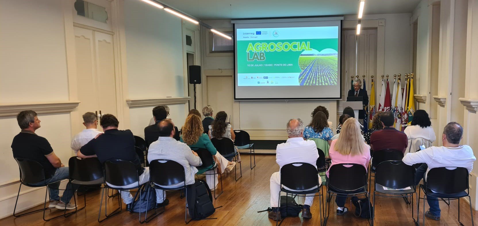 Imagem da sala do auditório com várias pessoas sentadas de frente para um púlpito, onde está o primeiro secretário da CIM AM a falar