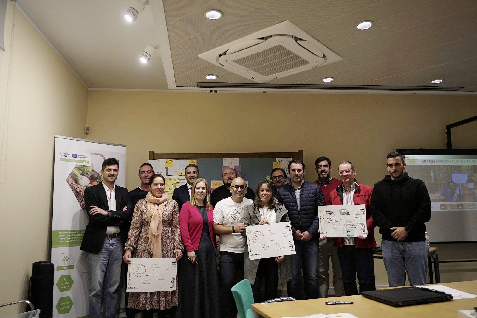 Participantes na sessão do projeto CIBUS de pé numa sala com cartazes nas mãos